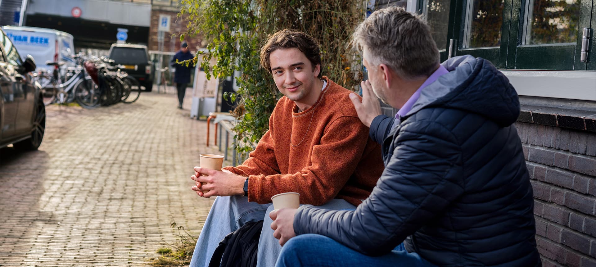Een jongere en een volwassene in gesprek